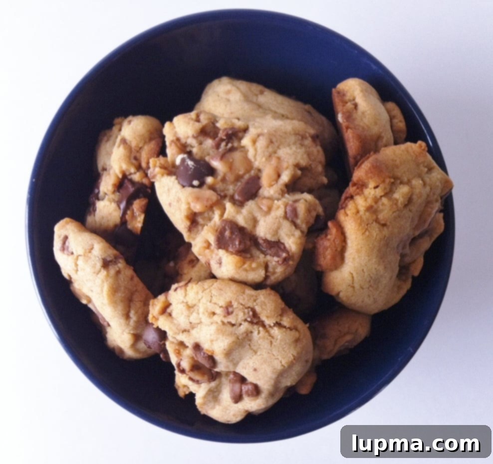 Peanut Butter and Toffee Cookies 2 A large bowl brimming with freshly baked, golden brown Peanut Butter Toffee Cookies, showcasing their delightful texture and inviting appearance.