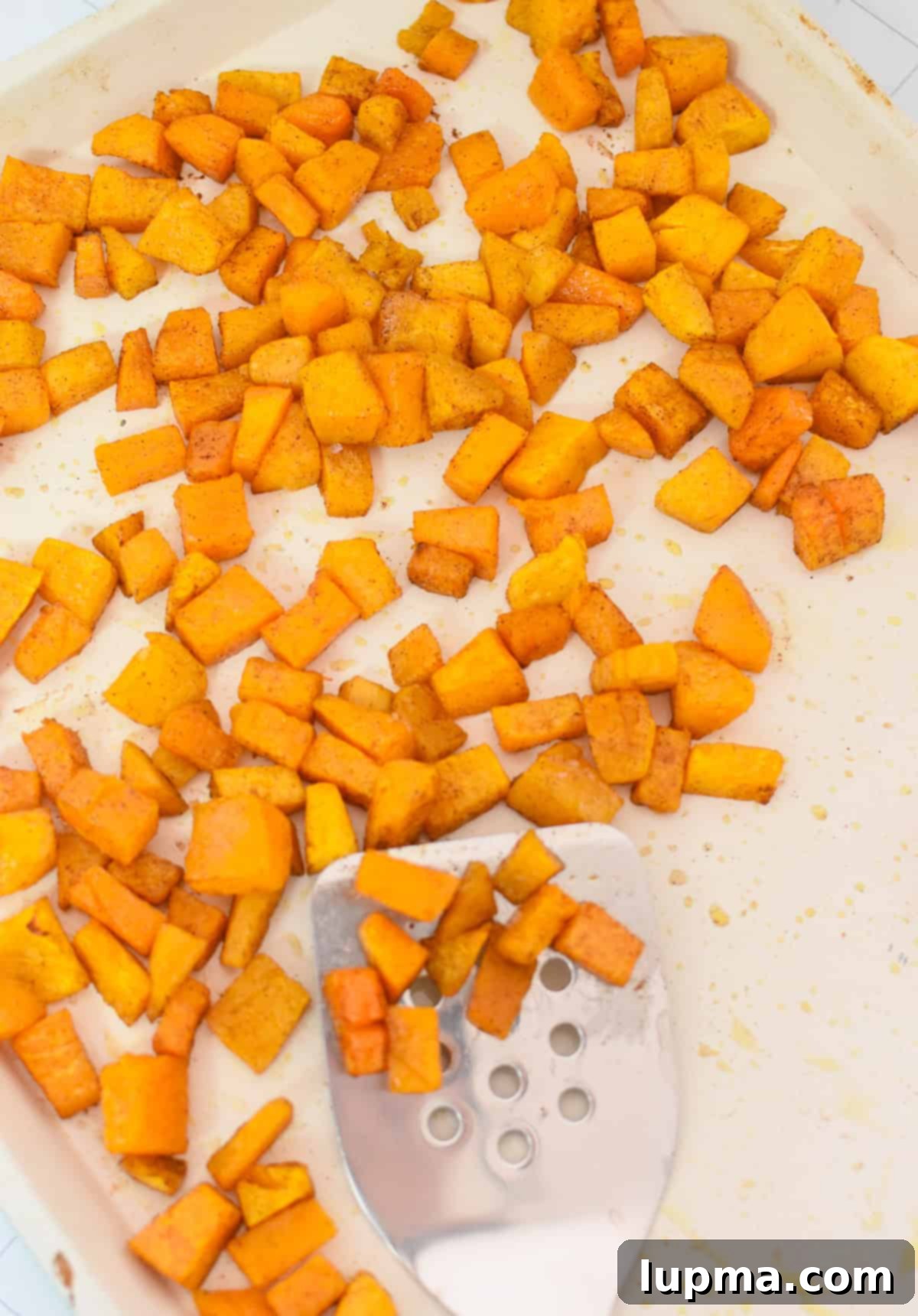 Hearty Autumn Orzo Salad 9 Perfectly roasted butternut squash, golden brown and tender, on a baking sheet.