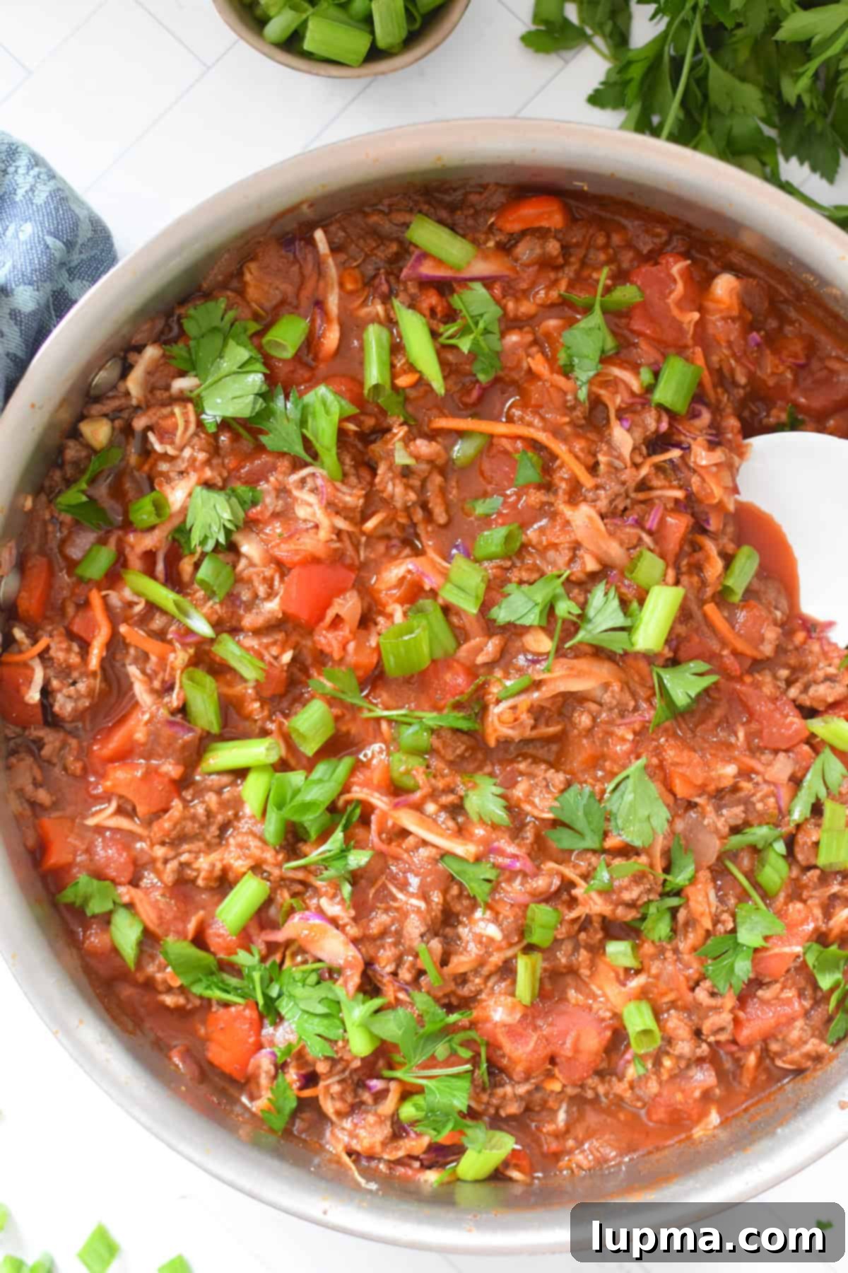Sun-Kissed Beef Cabbage Skillet 40 Mediterranean Beef and Cabbage Stir-fry in a skillet with a white spoon