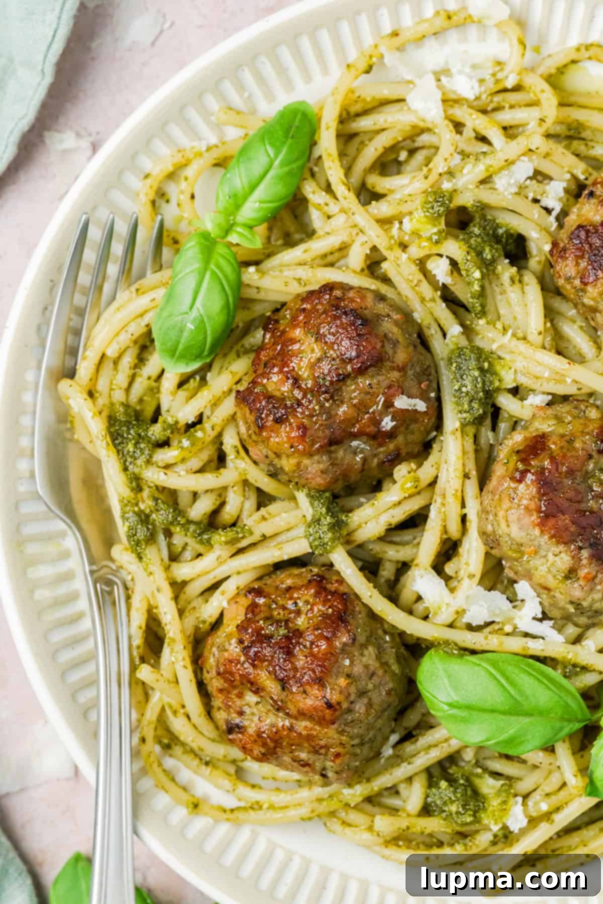 Turkish-Spiced Pesto Turkey Bites 2 Turkey Pesto Meatballs on a white plate with basil