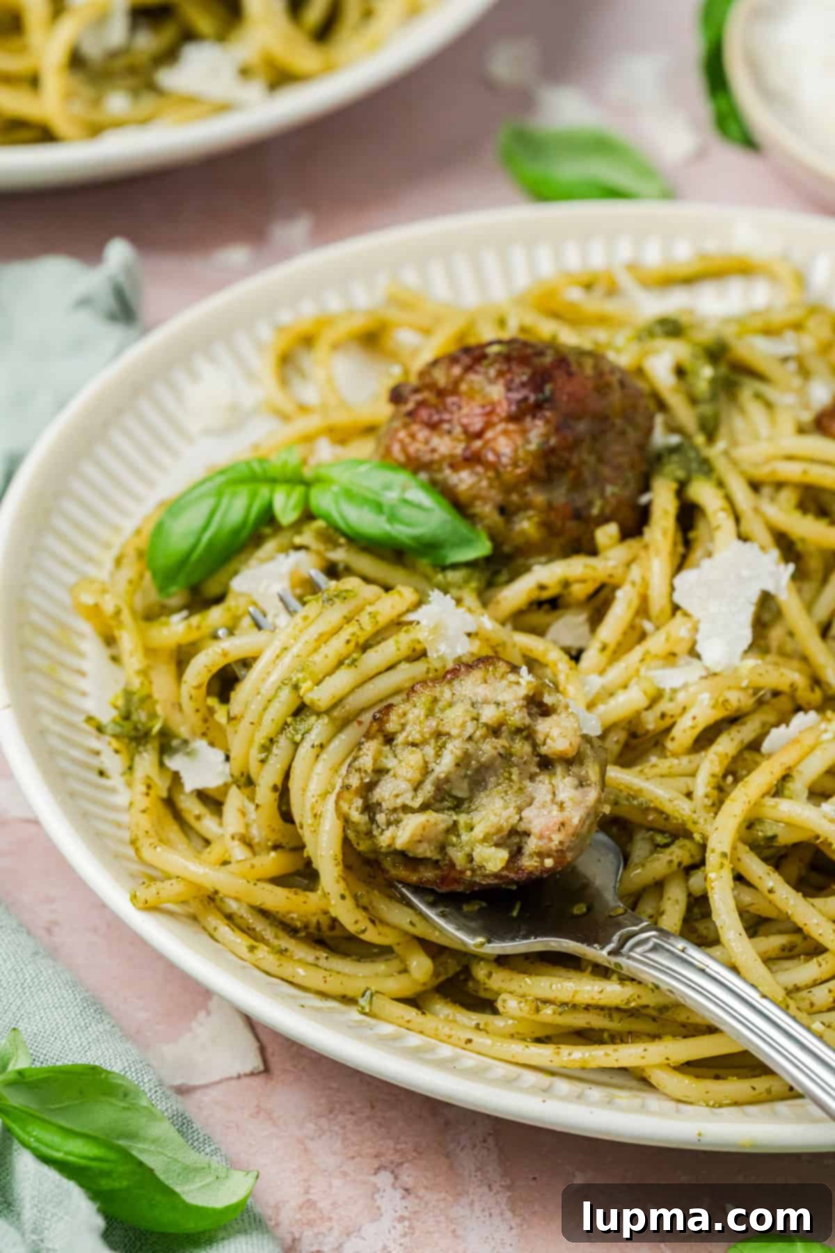 Turkish-Spiced Pesto Turkey Bites 9 meatballs in pesto sauce on a plate with a fork