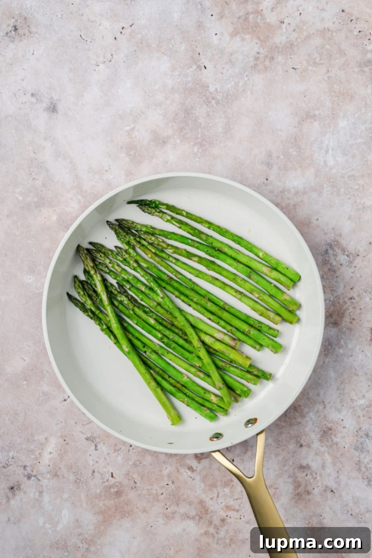 Easy Bourbon Glazed Salmon asparagus cooking in a skillet