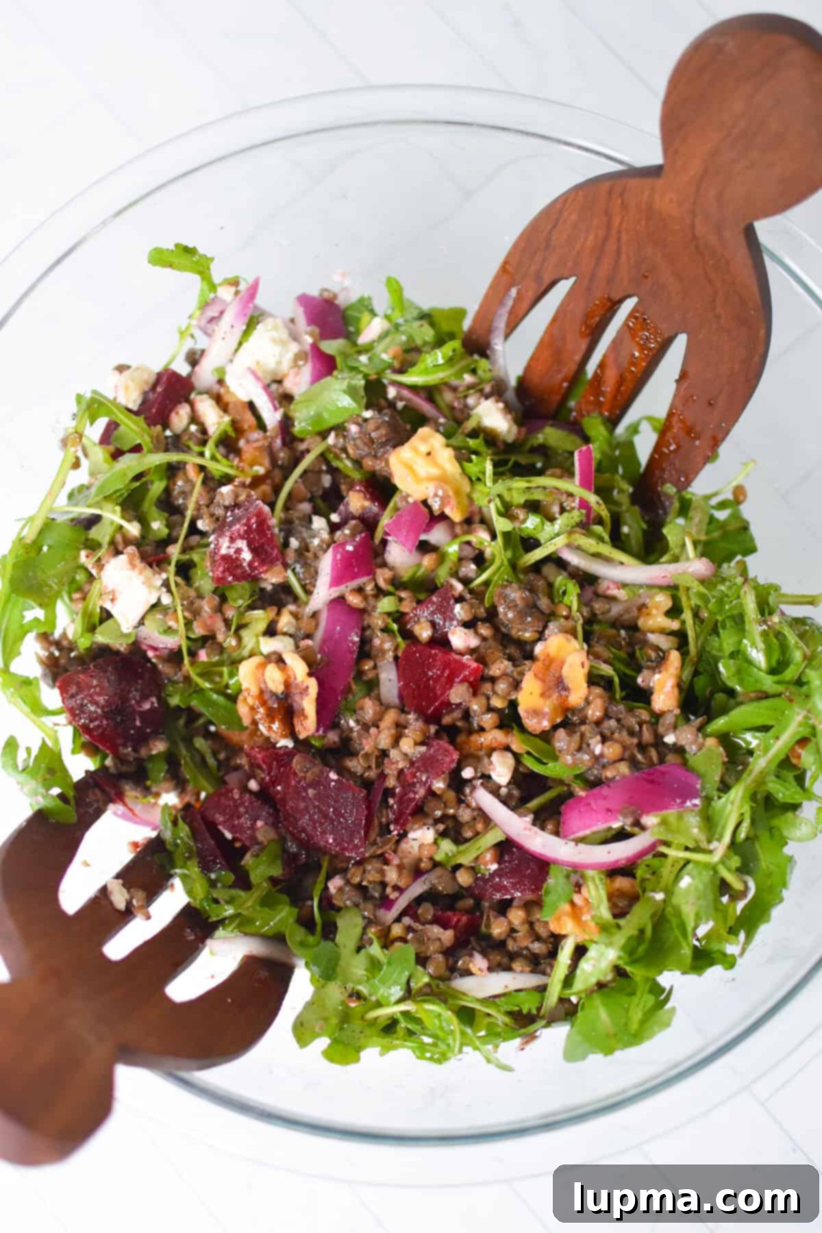 Mediterranean Lentil Beet Salad with Feta and Walnuts in a clean bowl with wooden spoons