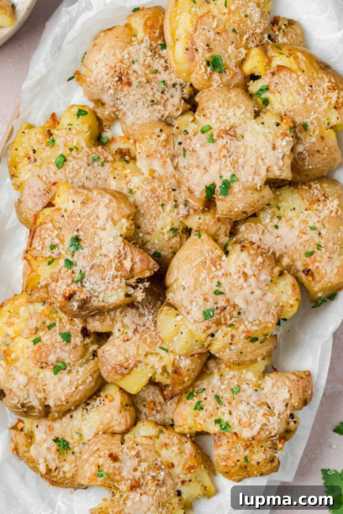 Garlic Parmesan Smashed Potatoes on a white plate