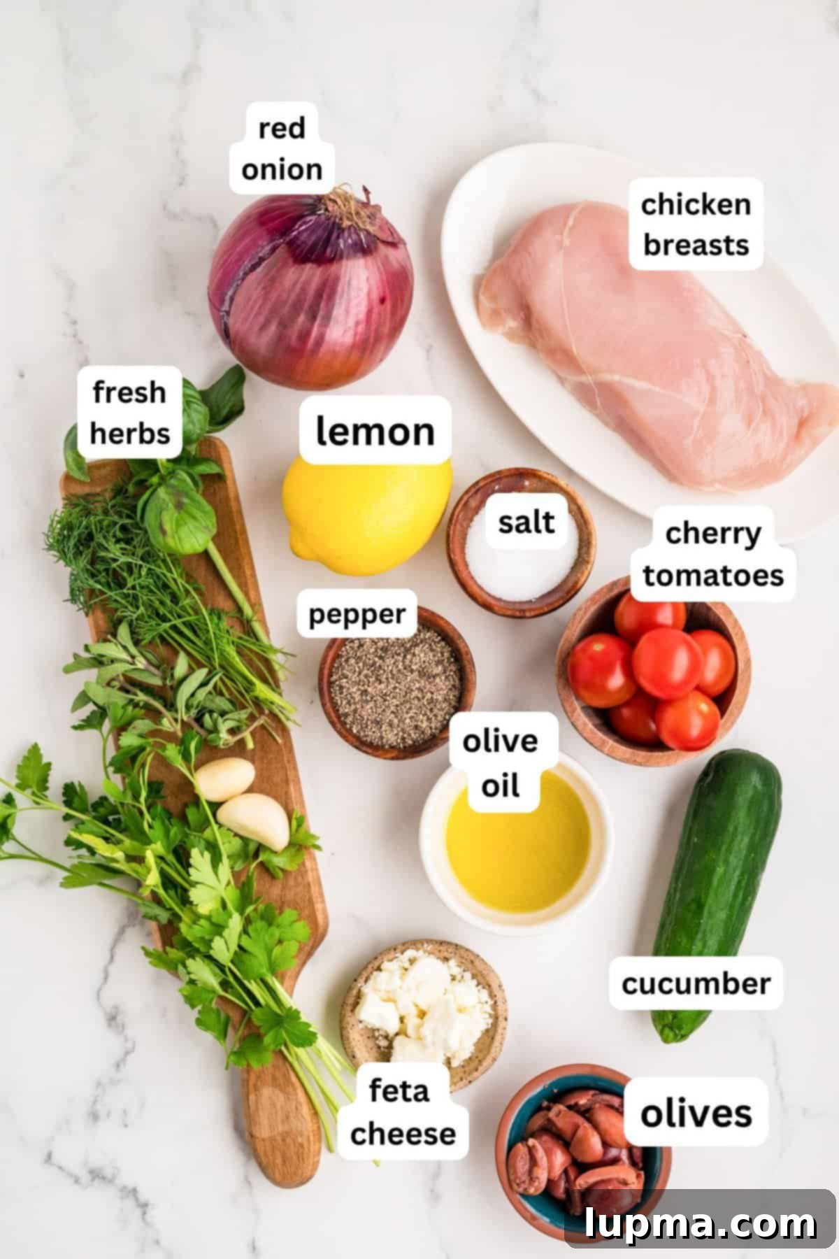 Fresh ingredients for the grilled Mediterranean chicken marinade, including lemon, olive oil, parsley, dill, oregano, and basil.