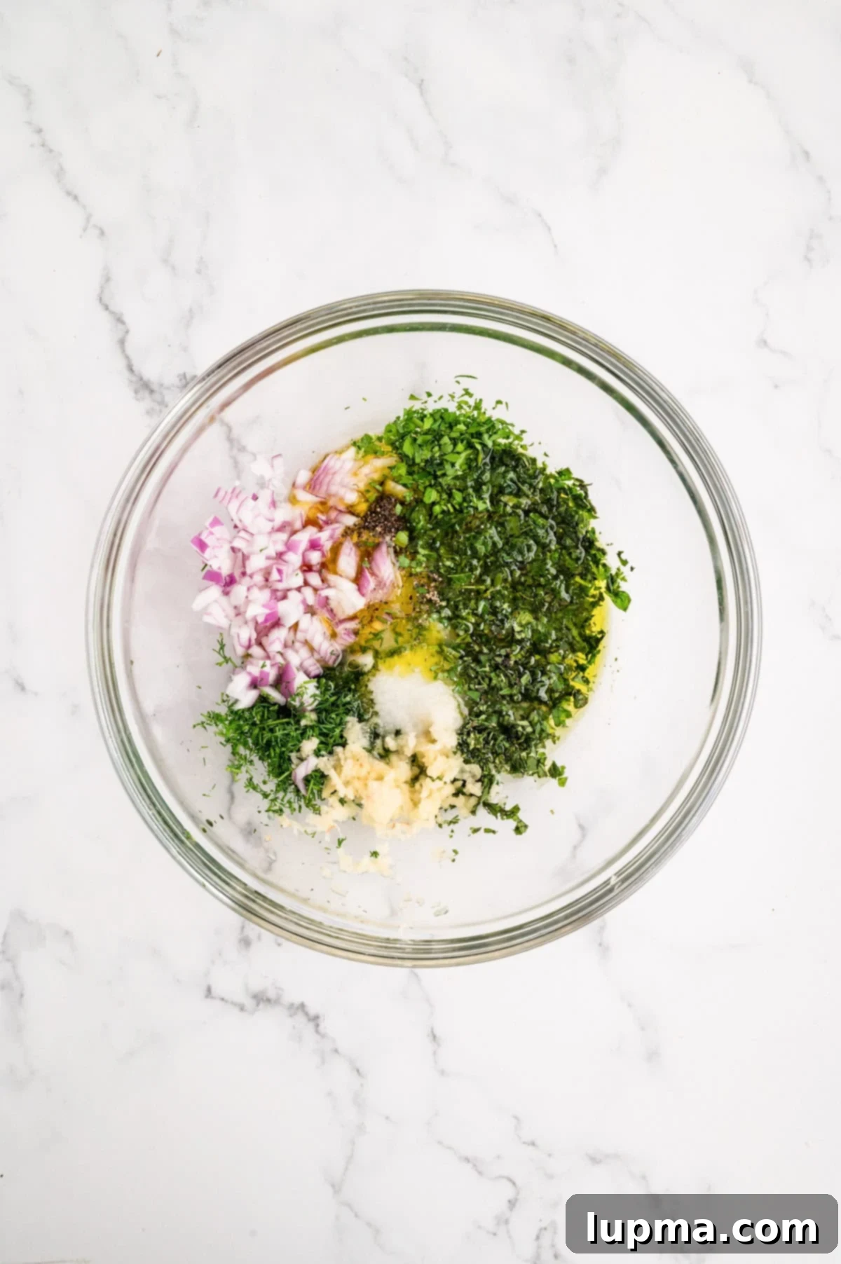 Ingredients for Mediterranean Chicken Breast Marinade whisked together in a bowl.