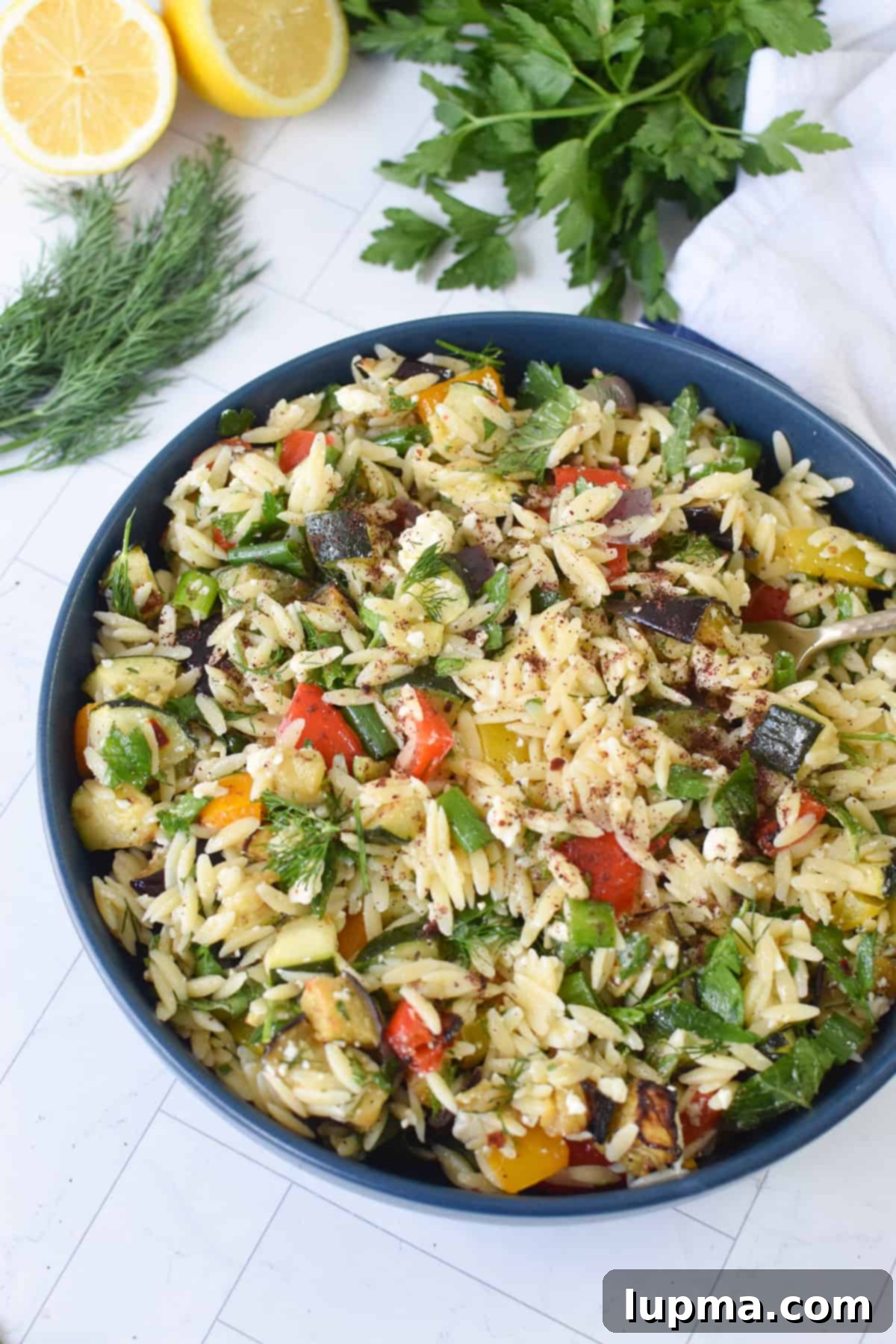 Roasted vegetable orzo salad with feta in a blue bowl