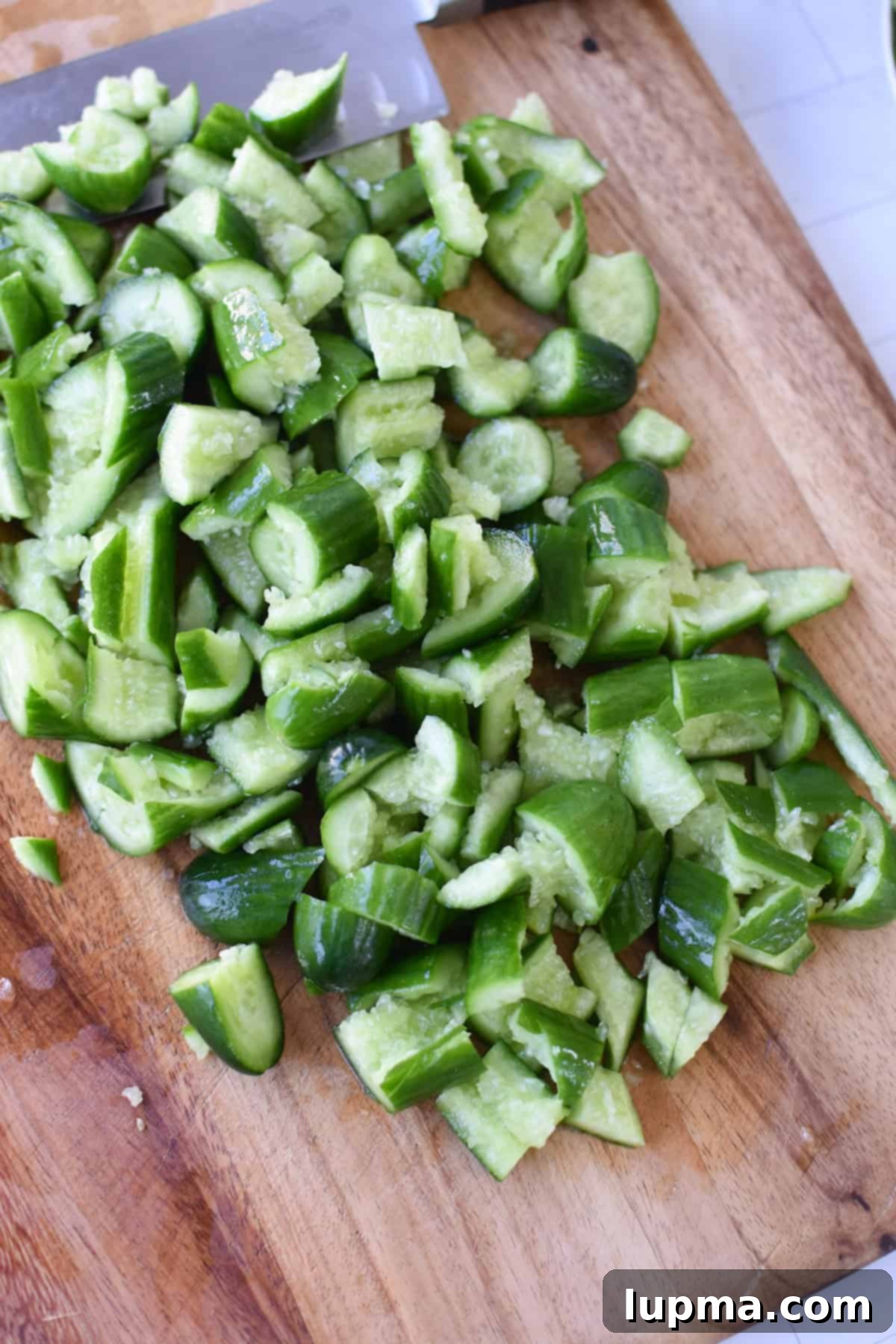 Fresh Persian cucumbers being smashed for the salad