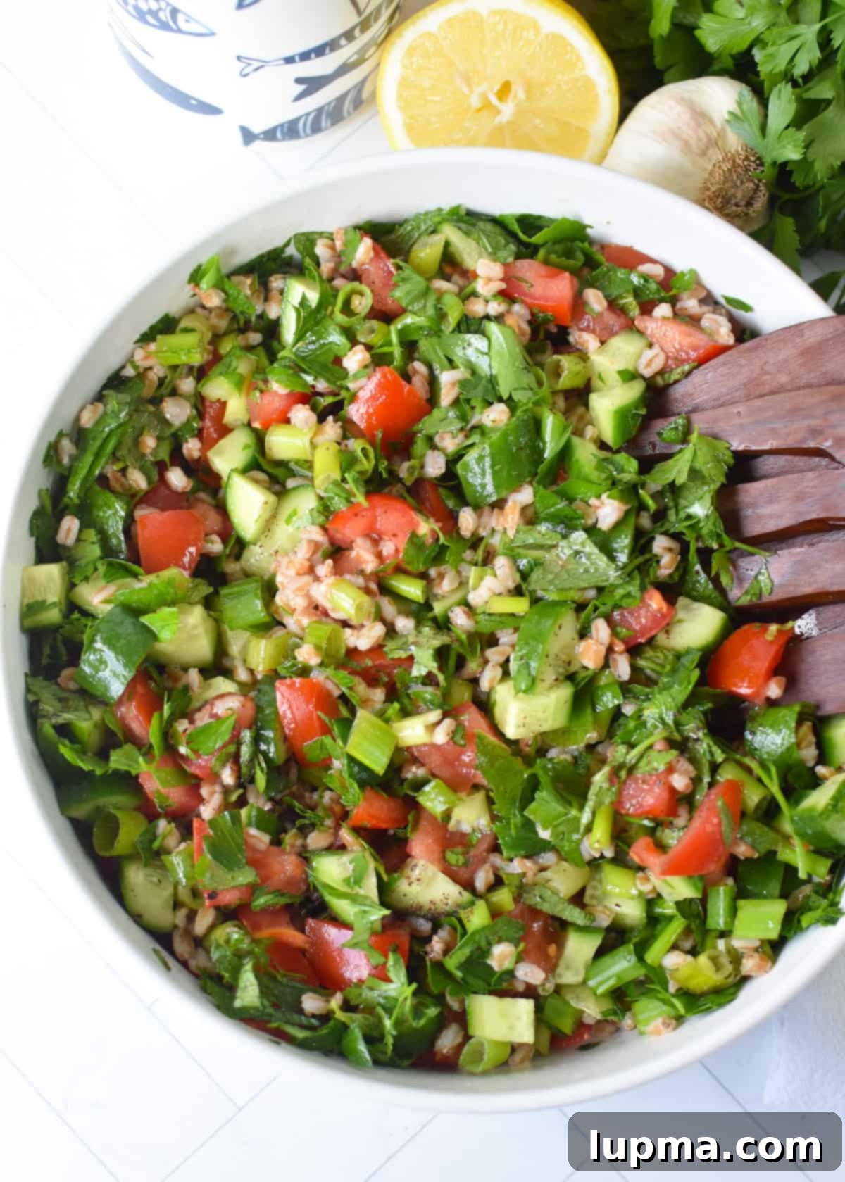 Delicious Farro Tabbouleh Salad in a white bowl, garnished with fresh parsley and crumbled feta cheese, showcasing its vibrant ingredients.