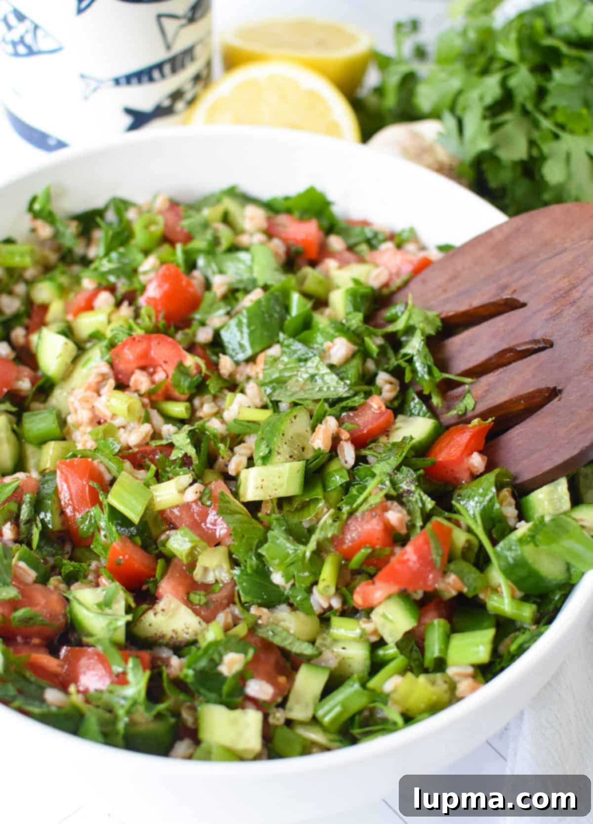 Authentic Lebanese-inspired farro tabbouleh salad with a bright lemon vinaigrette in a large glass bowl.
