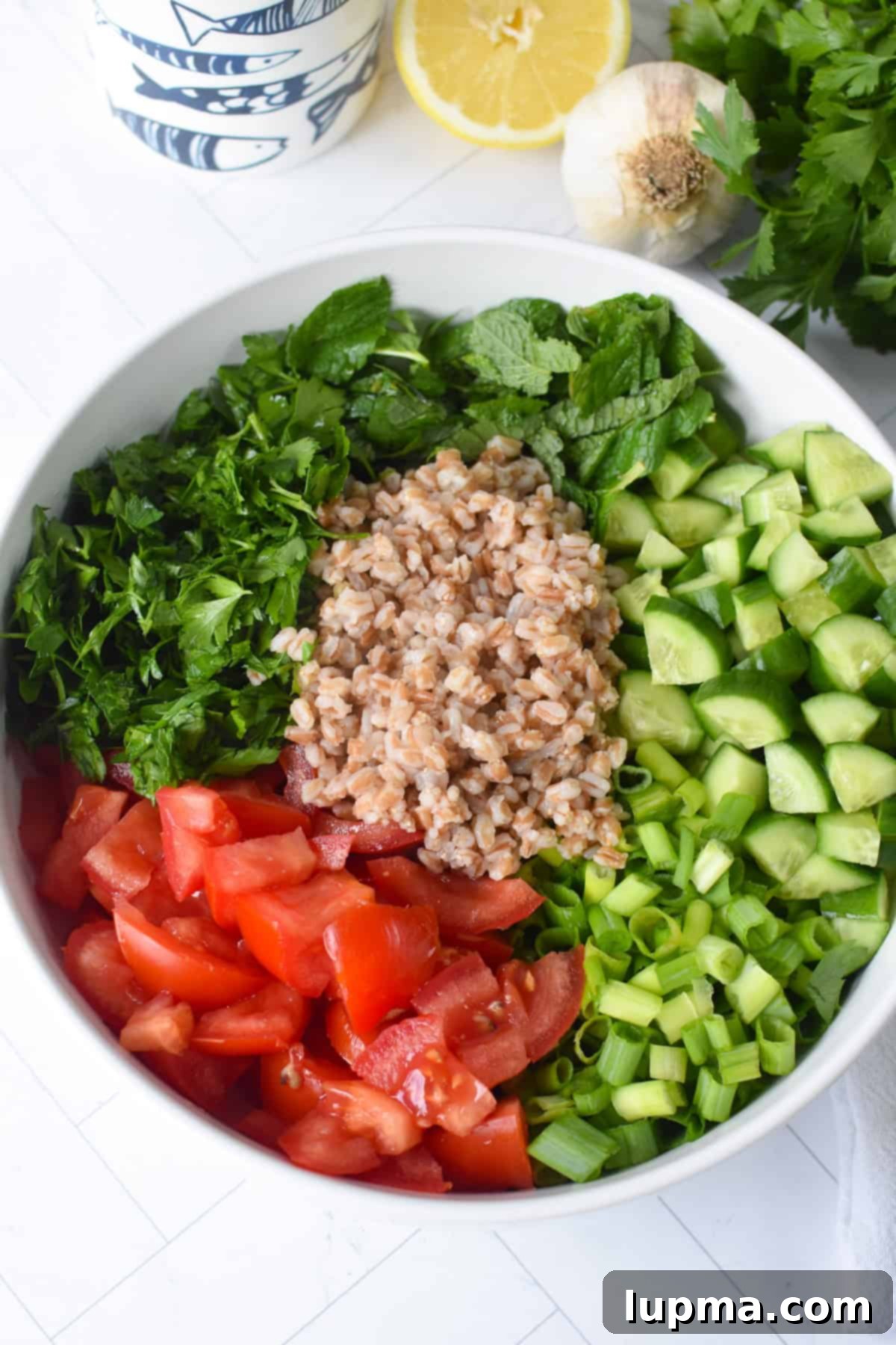 Beautifully mixed Simple Farro Tabbouleh Salad in a clear glass bowl, ready to be served.