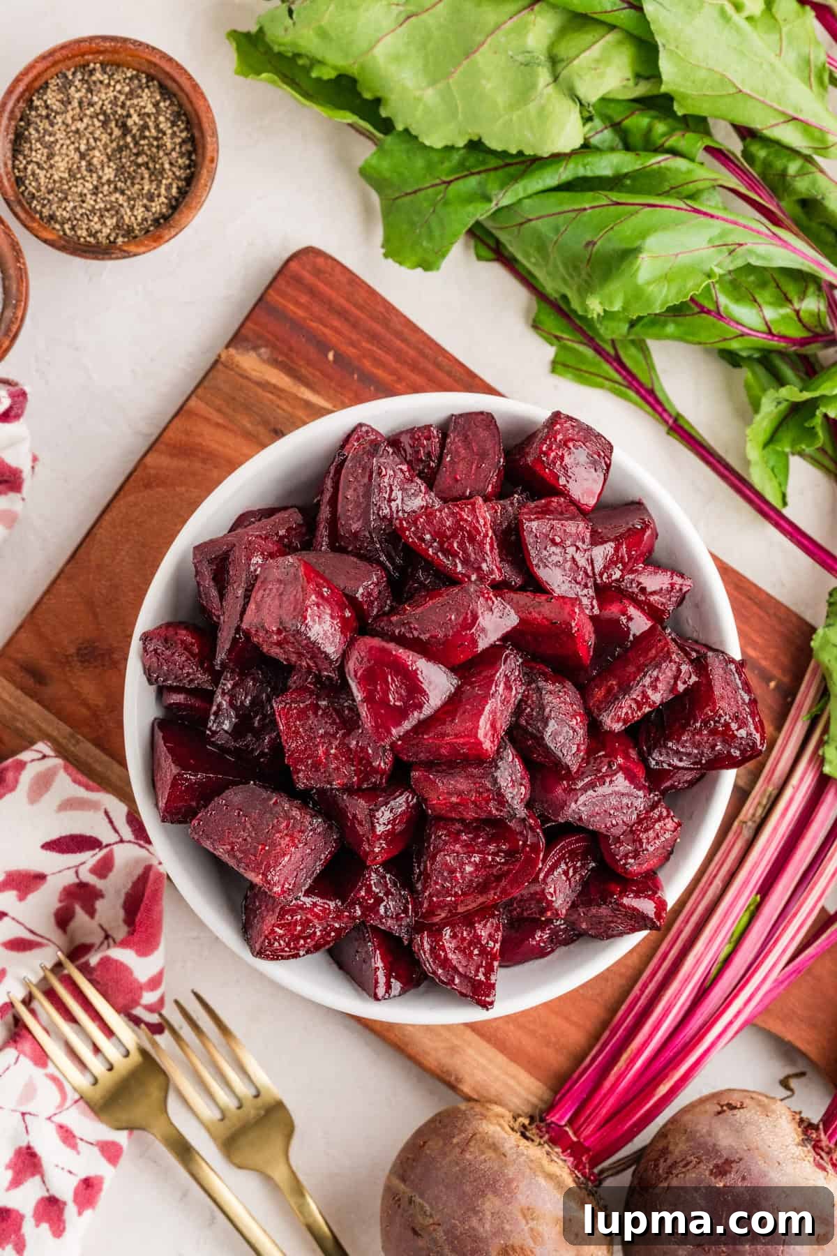 Fork tender oven roasted beets served in a shallow bowl with olive oil drizzle
