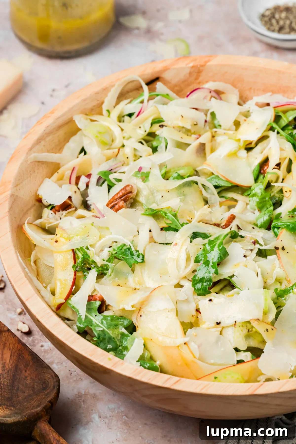 Overhead view of apple fennel salad with arugula, pecans, and Parmesan