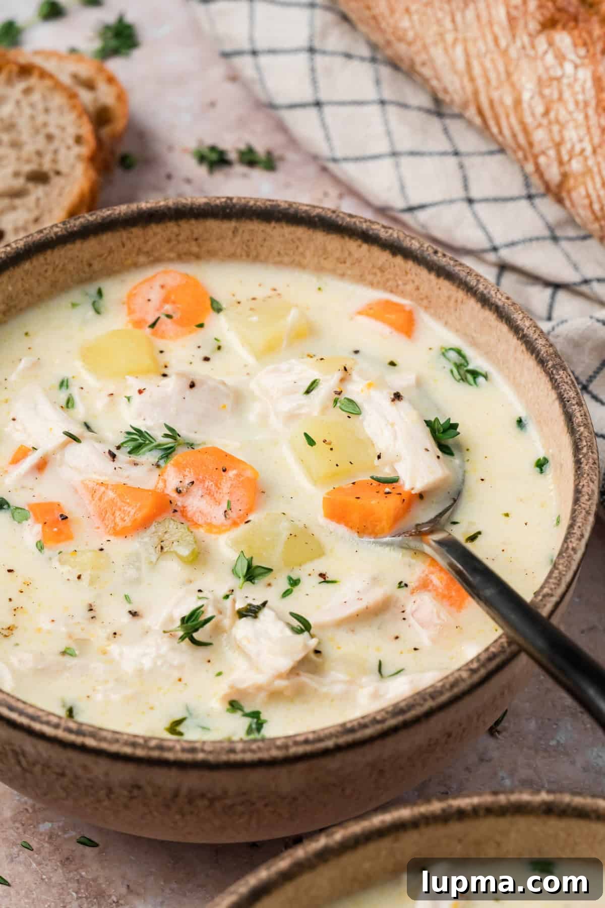 Creamy Chicken and Potato Soup Without Heavy Cream 11 Bowl of creamy chicken potato soup topped with fresh thyme and cracked black pepper