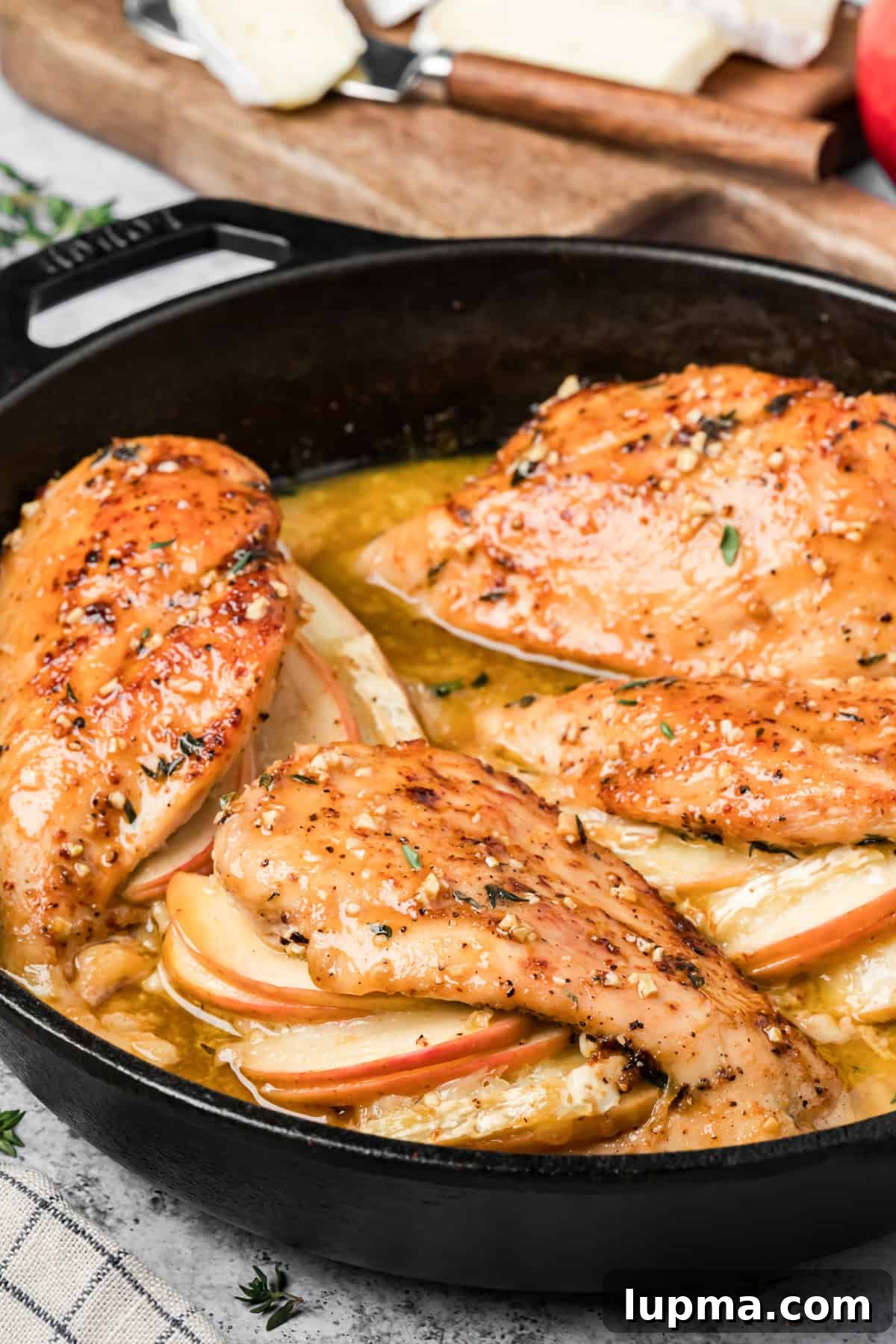 Close-up of melted Brie and apple filling inside baked stuffed chicken