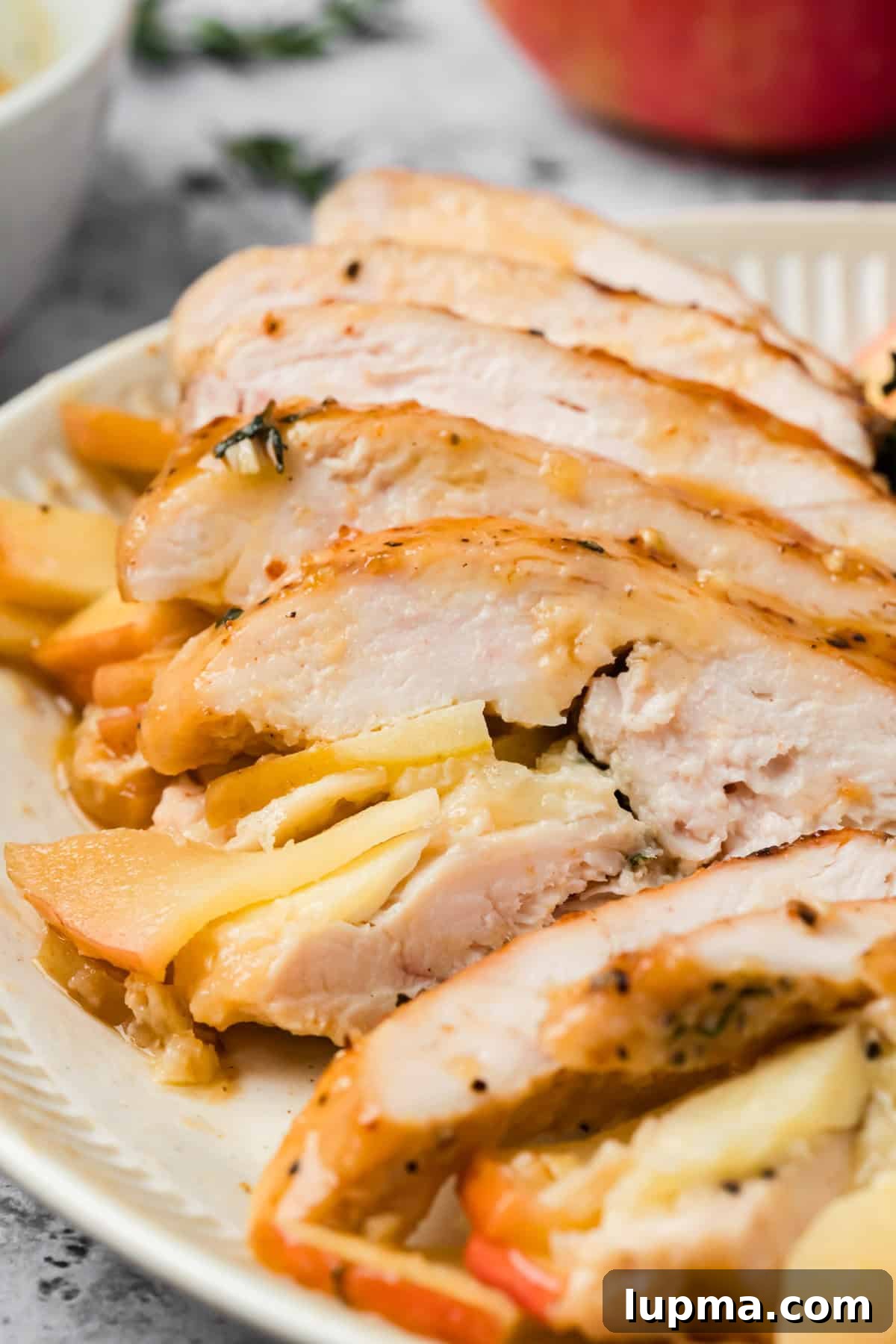 Sliced section of apple and brie stuffed chicken with maple Dijon glaze