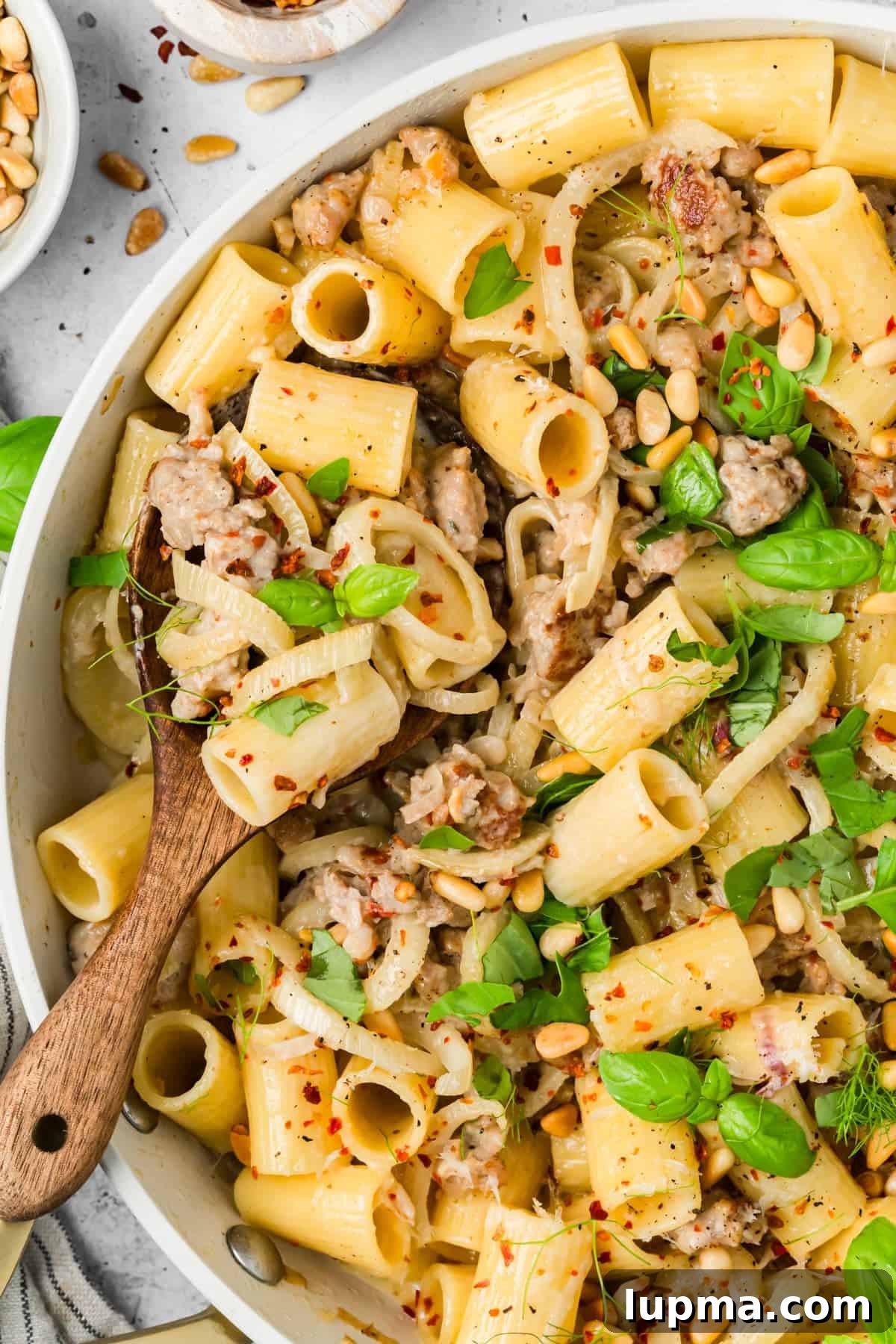 Sausage and Fennel Pasta with Lemon and Parmesan 6 Close-up of creamy sausage and fennel pasta topped with toasted pine nuts and Parmesan