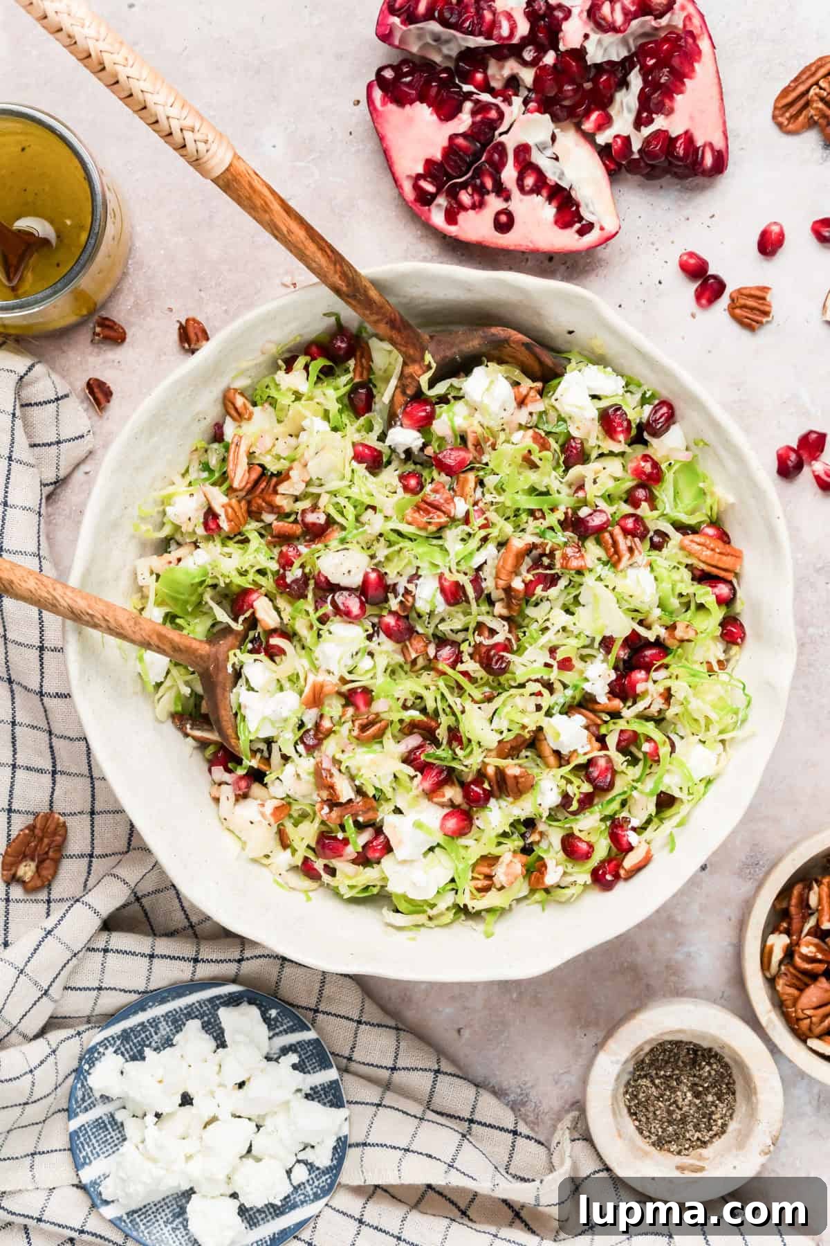 Crumbled goat cheese being sprinkled over Brussels sprouts salad
